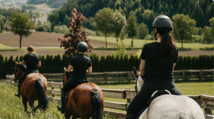 Guests horseback riding through a summer valley